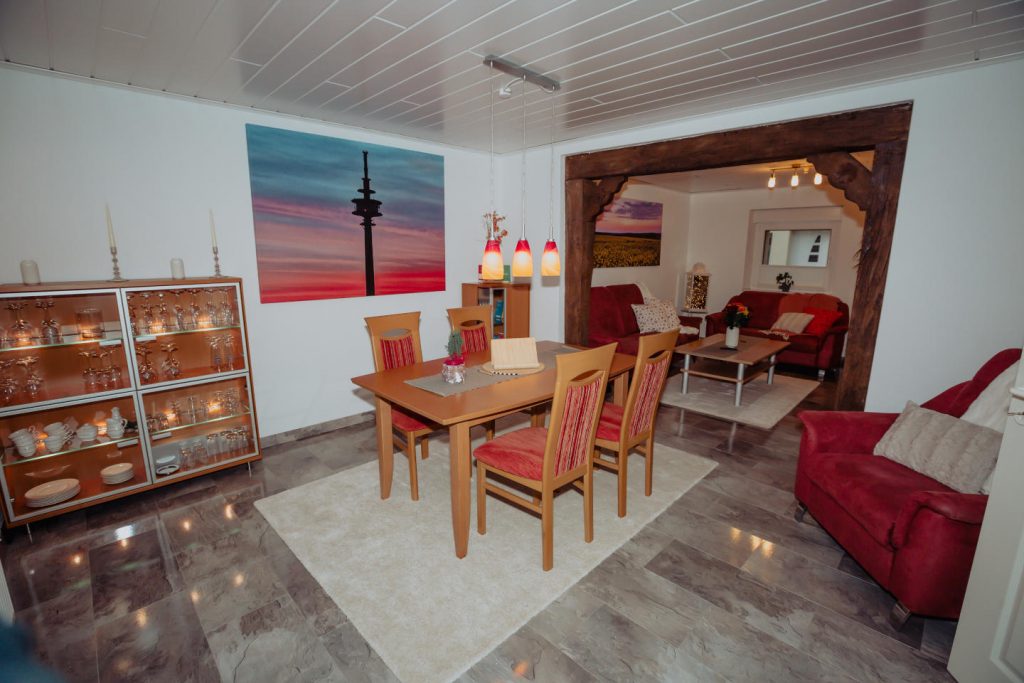 Offener Essbereich mit beleuchteter Vitrine und Durchgang zum Wohnzimmer im Ferienhaus CaSa Hürtgenwald