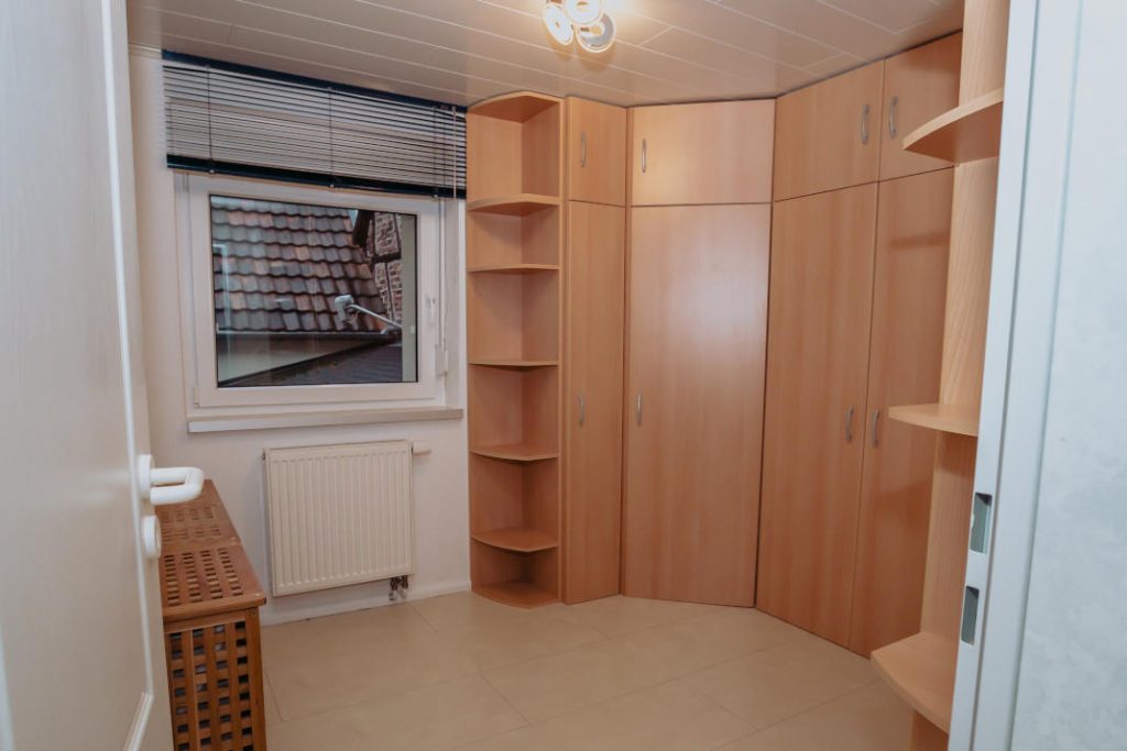 Separates Ankleidezimmer mit großem Eckschrank und Fenster